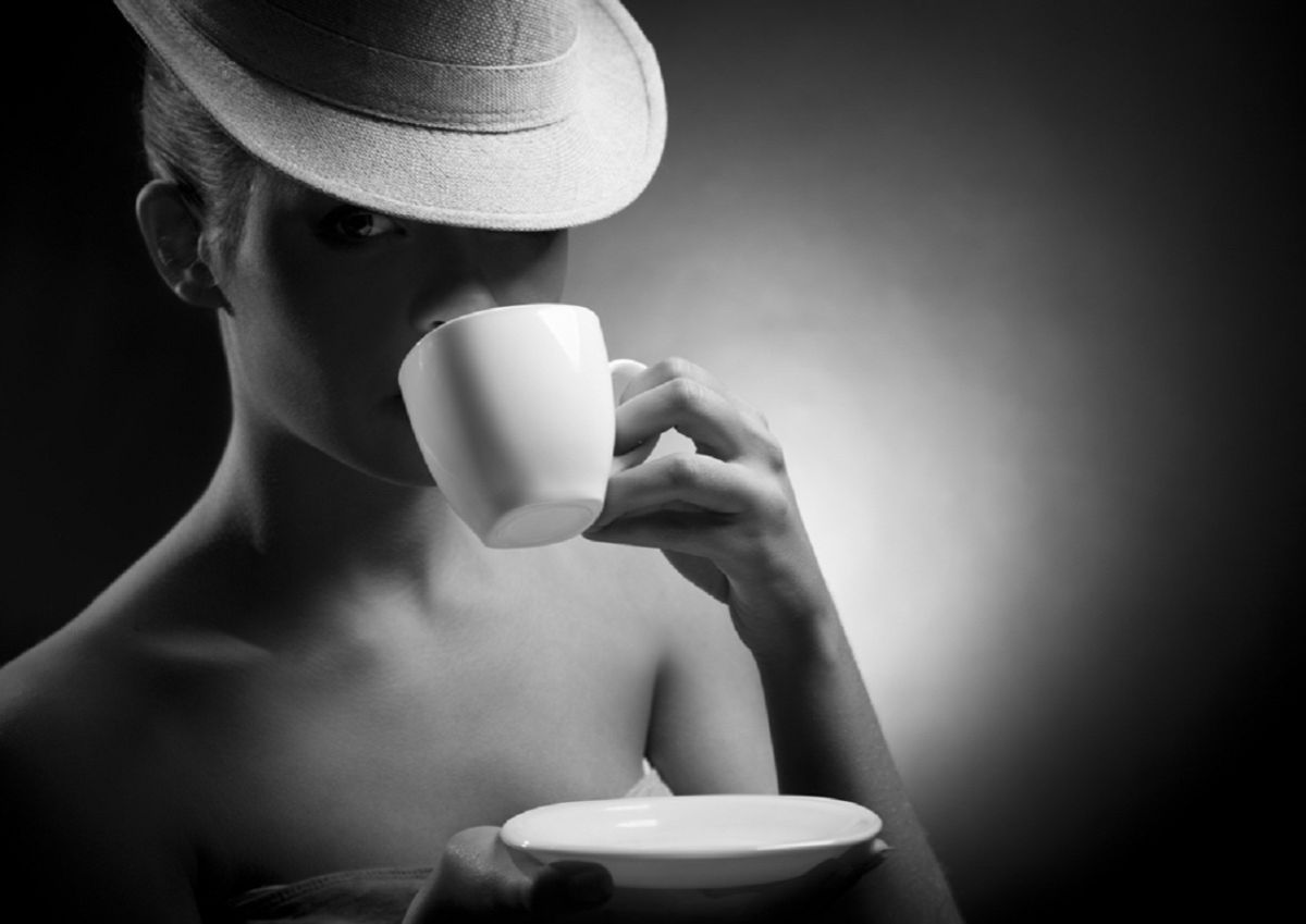 Молодая девушка пьет кофе обнаженная